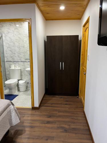 a room with a bathroom with a toilet and a door at Hostería Estelita in Panimávida