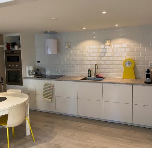 una cocina con armarios blancos y un pato amarillo en la encimera en Casa Annie & Nadja - Toppmodernt centralt i Borgholm, en Borgholm