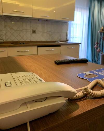 a phone sitting on top of a wooden desk at Royal Butik House in Bursa