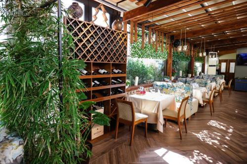 a dining room with tables and chairs and plants at Vila Ferdinand Modern Rooms In Tirana's Center in Tirana