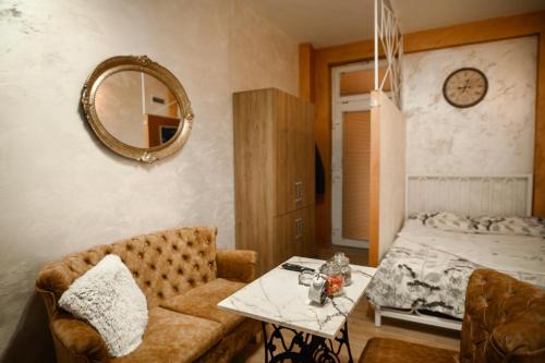 LazarevacにあるStan11550 Centarのソファ、テーブル、ベッドが備わる客室です。