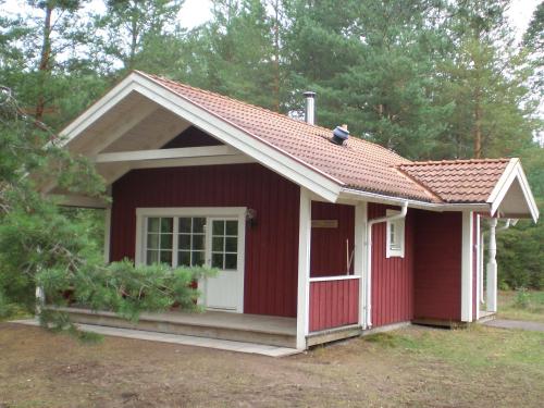 a red shed with a white door and a window at First Camp Enåbadet - Rättvik in Rättvik