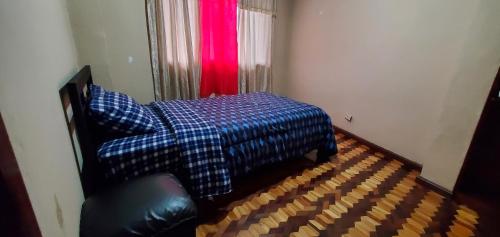 a bedroom with a bed and a red curtain at Departamento en Cuenca, 3 Habitaciones y parqueo gratis in Cuenca