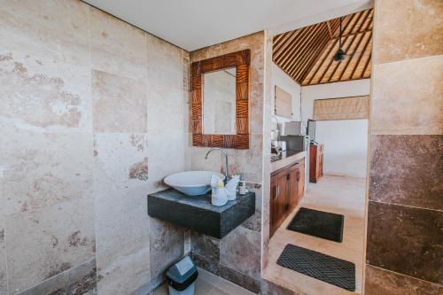 y baño con lavabo y espejo. en Villa Mimpi Manis, en Nusa Lembongan