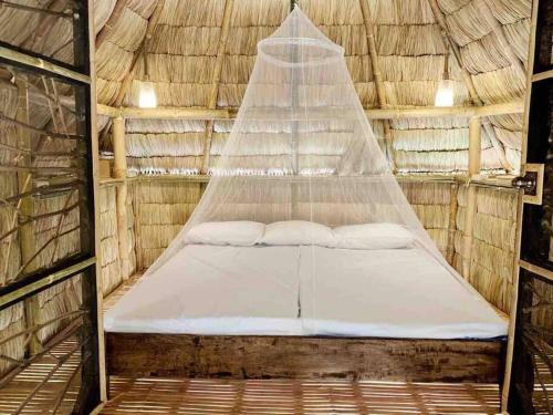 Bett in einem Zimmer mit einem Netz in der Unterkunft Tree House by the Ocean ( for 2 guests) in Calatagan