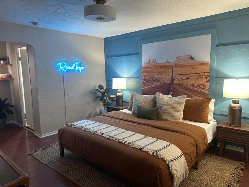 1 dormitorio con 1 cama con una pintura en la pared en El Trovatore Motel, en Kingman