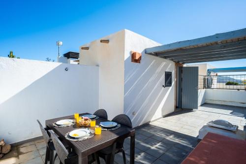 een tafel en stoelen op het balkon van een huis bij Trendy Homes Casa Nerida in Rodalquilar