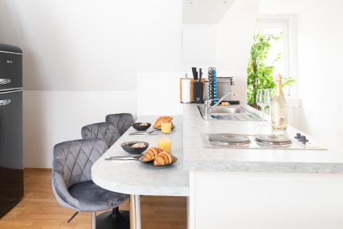 uma cozinha com uma mesa com pão e sumo de laranja em Comfy Downtown Loft - Self Check-in - Centre of Graz em Graz