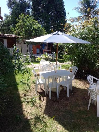 a white table and chairs with an umbrella at Pousada Pôr do Sol in Barra Grande