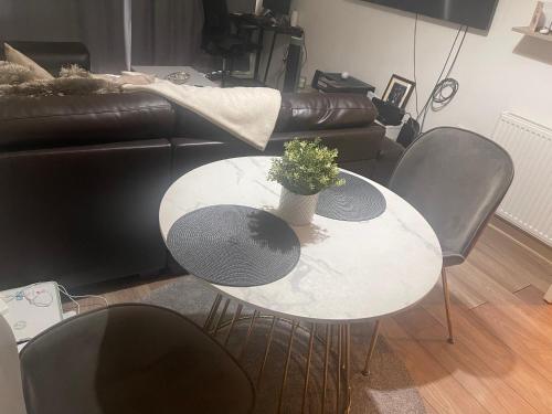 a table and chairs in a living room with a plant at Homely abode in Croydon