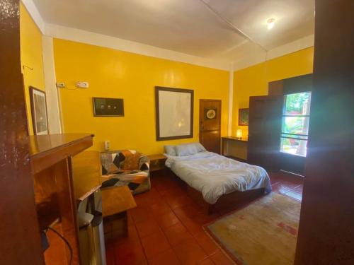 a bedroom with a bed and a yellow wall at Villa del Mar in Mactan
