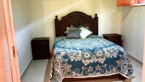 a bedroom with a bed with a blue and white blanket at Hostal la nube in San Cristóbal de Las Casas