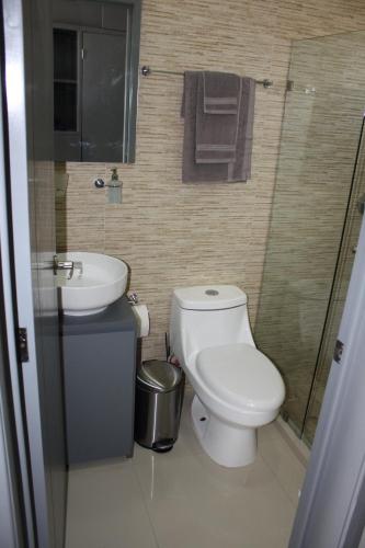 een badkamer met een wit toilet en een wastafel bij 2br/2ba Condo 1 block to ocean! - Unit 4 in Mazatlán