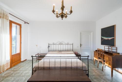 1 dormitorio con 2 camas y lámpara de araña en La Trifoglietta, en Cetona