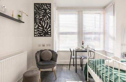 um quarto com uma cama, uma cadeira e uma mesa em New renovated studio flat with separate kitchen and bathroom em Southall