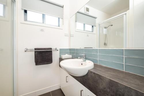 bagno bianco con lavandino e specchio di Ingenia Holidays Murray Bend a Koonoomoo