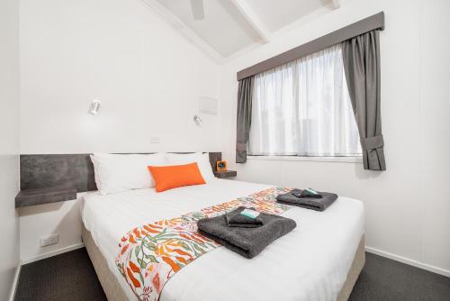 a bedroom with a large bed with towels on it at Ingenia Holidays Murray Bend in Koonoomoo