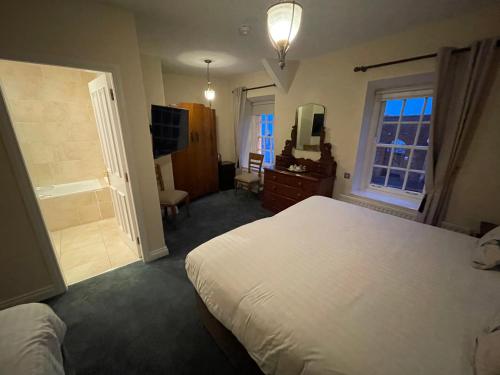 a bedroom with a white bed and a bathroom at The Portaferry Hotel in Portaferry