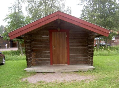 a small wooden out house with a red roof at First Camp Enåbadet - Rättvik in Rättvik