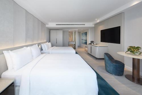 a hotel room with a large white bed and a tv at JW Marriott Gold Coast Resort & Spa in Gold Coast