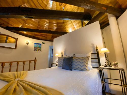 a bedroom with a large bed with wooden ceilings at Moinho Da Pena - Alojamento Local in Bairro