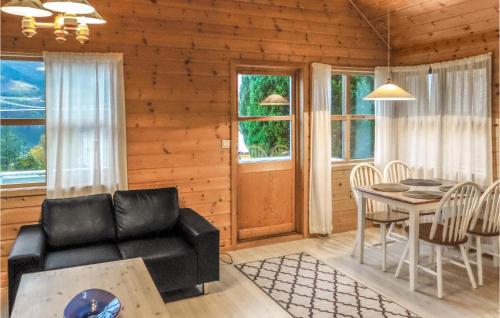 a living room with a black couch and a table at 3 Bedroom Pet Friendly Home In Vallavik in Vangsbygd