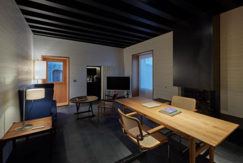 a living room with a wooden table and chairs at Casa Palacio PAREDES SAAVEDRA by ATRIO in Cáceres