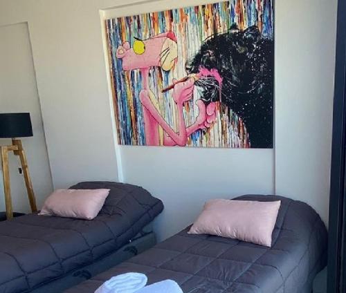 Habitación con 2 camas y una pintura en la pared. en Double or 2-3 Beds Private Studio - PinkPanther en Buenos Aires