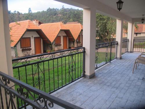 a balcony with an iron fence and a house at Pousada Vilas di Espanha in Monte Verde