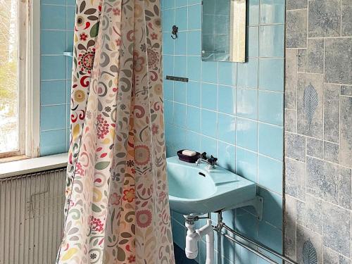 a bathroom with a sink and a shower curtain at Holiday home ÖSTRA ÄNTERVIK II in Östra Ämtervik