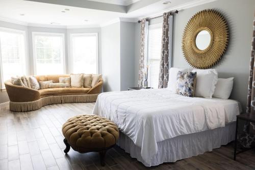 - une chambre avec un lit, un canapé et un miroir dans l'établissement SoulBeatz Country Mini Mansion w/ Pool & Putting Green, à Hope Hull