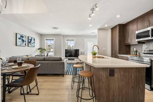 a kitchen and living room with a couch and a table at Stylish 3BR Townhouse by Airport in Calgary