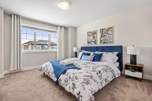 a bedroom with a large bed and a window at Stylish 3BR Townhouse by Airport in Calgary