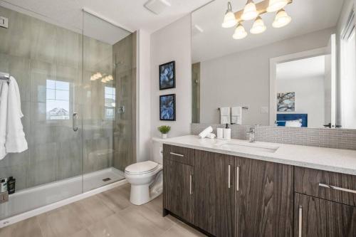 a bathroom with a sink and a toilet and a shower at Stylish 3BR Townhouse by Airport in Calgary