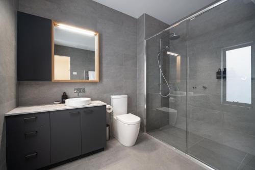 a bathroom with a shower and a toilet and a sink at Sheppard Art House Townhouse in Bright