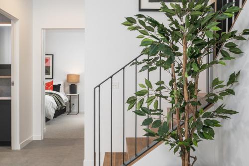 a staircase with a plant next to a bedroom at Sheppard Art House Townhouse in Bright