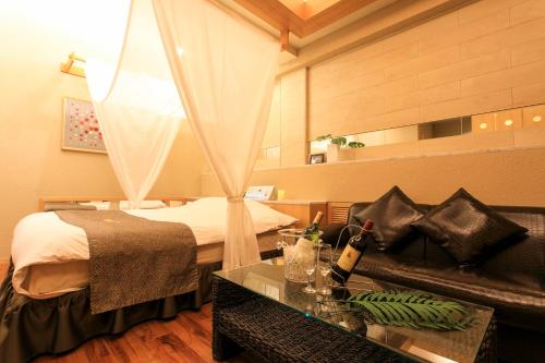 a hotel room with a bed and a couch at HOTEL D 川越 -Adult Only- in Kawagoe