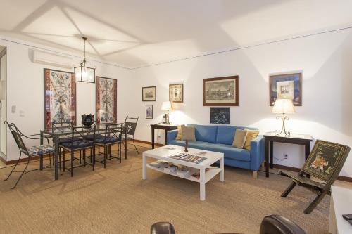 a living room with a blue couch and a table at Bairrus Lisbon Apartments - Alfama II in Lisbon