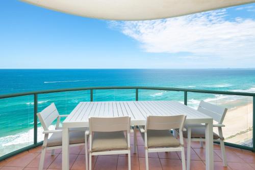 a white table and chairs on a balcony with the ocean at The Waterford on Main Beach in Gold Coast