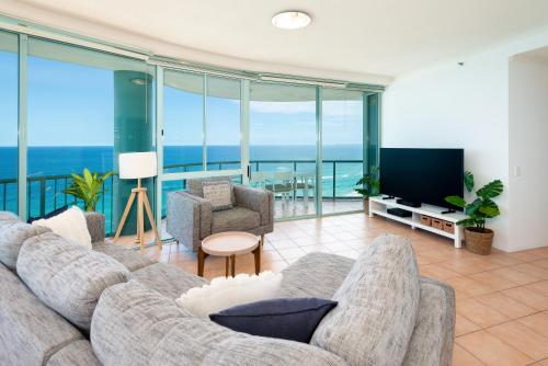a living room with a couch and a flat screen tv at The Waterford on Main Beach in Gold Coast