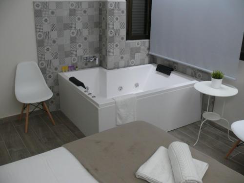 La salle de bains blanche est pourvue d'une baignoire et d'une table. dans l'établissement HOSTAL LETTO DAL MARE, à Valence