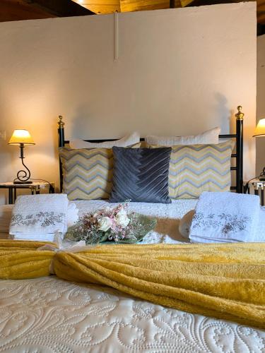 a large bed with a blanket and flowers on it at Moinho Da Pena - Alojamento Local in Bairro