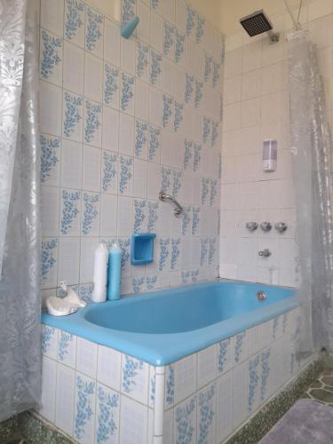 Habitación con baño con bañera azul. en Preciosa Casa Centrica y Acogedora, en Tarija