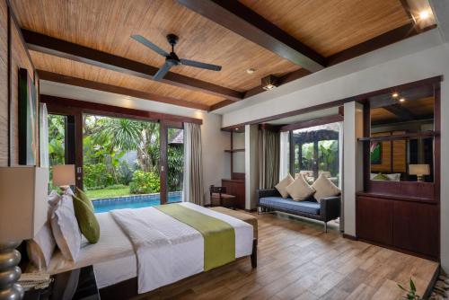 a bedroom with a bed and a ceiling fan at Le Jardin Villas Seminyak in Seminyak