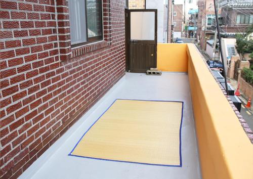- un tapis sur le balcon d'un bâtiment dans l'établissement Bird Village Guesthouse Rook, à Ulsan