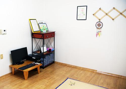 Cette chambre dispose d'un bureau et d'un ordinateur sur une table. dans l'établissement Bird Village Guesthouse Rook, à Ulsan