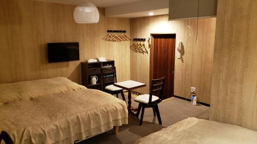 a bedroom with a bed and a desk and a tv at Fukiya in Gero
