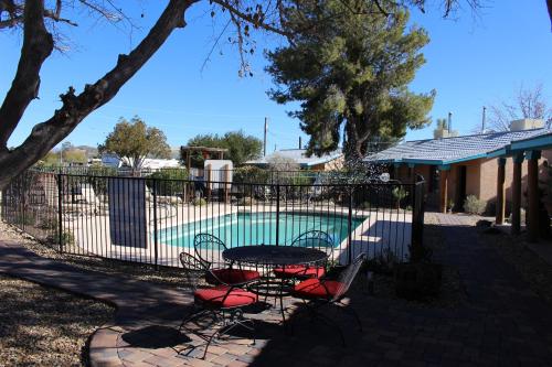 a table and two chairs in front of a pool at My Place Suites in Wickenburg