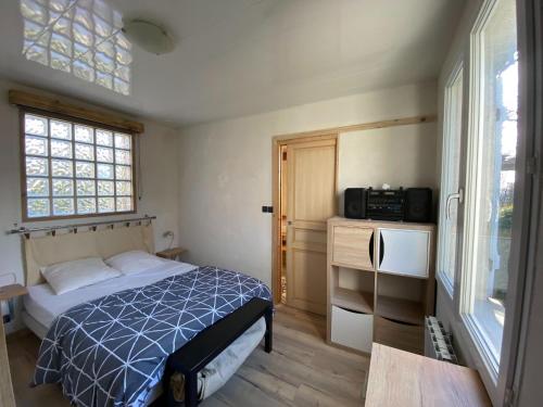 um quarto com uma cama, uma televisão e uma janela em Charming holiday home in a quiet location, near the coast, 2 bicycles em Donville-les-Bains