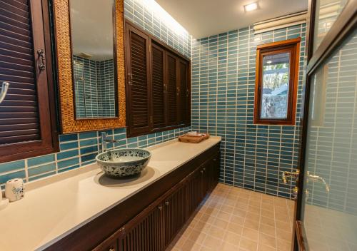 bagno con pareti piastrellate blu e lavandino di Tina Holiday Homes a Ko Chang